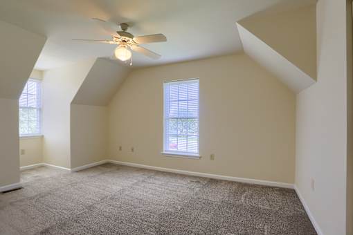 A room with a ceiling fan and a window.