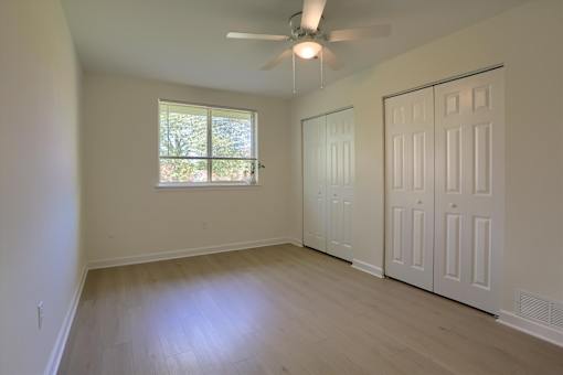 A room with a ceiling fan and a window.