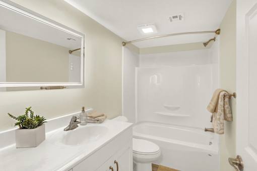 A white bathroom with a toilet, sink, and tub.