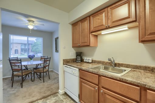 Mechanicsburg Apartments | Delbrook Manor Apartments | a kitchen with wooden cabinets and a white dishwasher