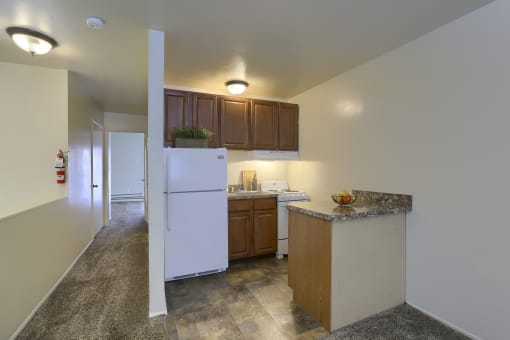 a kitchen with white appliances and brown cabinets and a white refrigerator