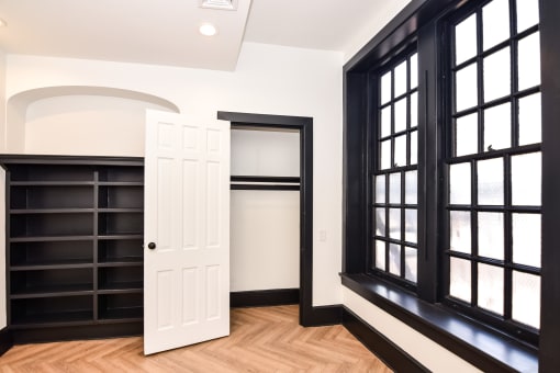 a room with black windows and a white door and a book shelf