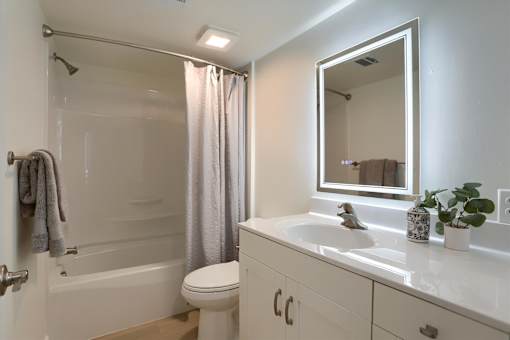 A white bathroom with a toilet, sink, and bathtub.