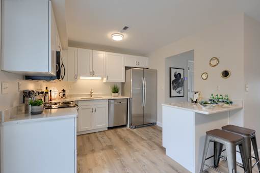 A kitchen with white cabinets and a refrigerator.