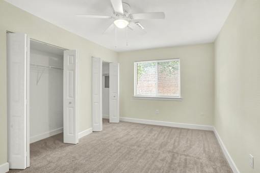 A room with a ceiling fan and a window.