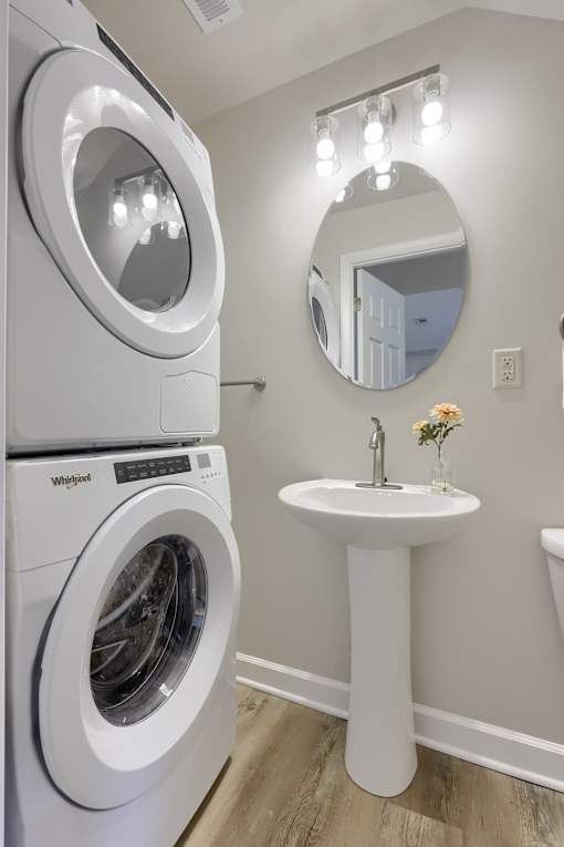 A white washing machine and sink in a laundry room.