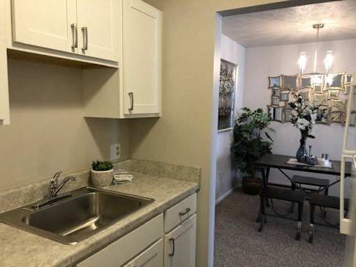 A kitchen with a sink and a dining table.