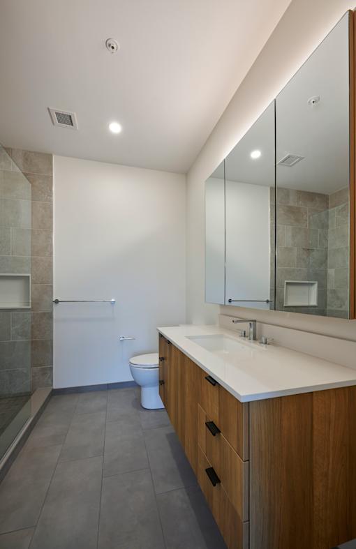 a bathroom with a large mirror and a sink and a toilet
