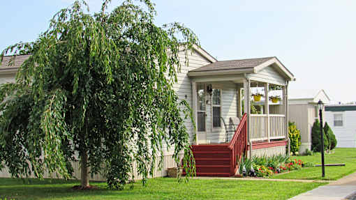 A house with a red staircase and a tree in front.