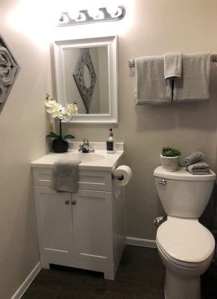 A white toilet sits next to a white sink in a bathroom.