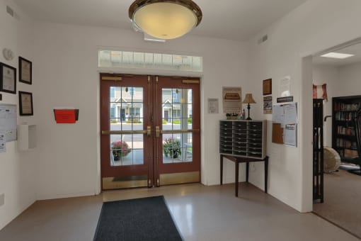the lobby of the library with double doors and a rug