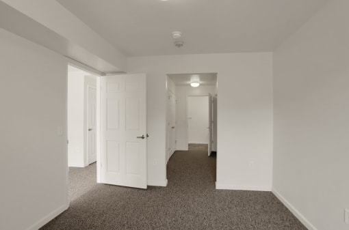 a bedroom with white walls and white doors and carpeting