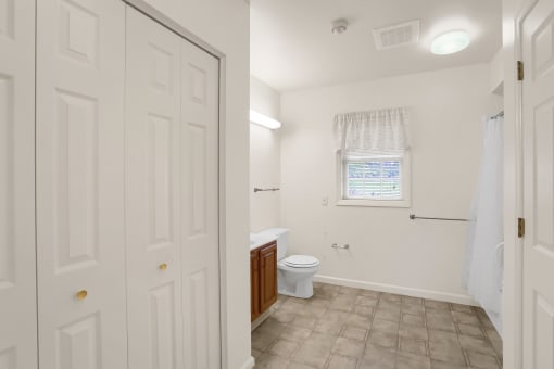 a bathroom with a toilet and a sink and a window