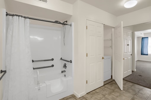 a white bathroom with a shower and a tub and a closet