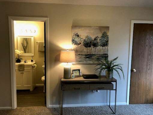 A bathroom with a vanity and a painting on the wall.