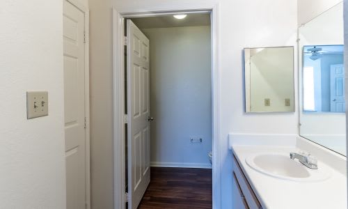 A white bathroom with a sink and mirror.