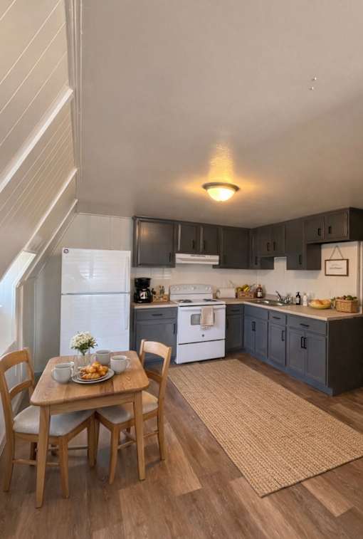 A kitchen with a table and chairs.