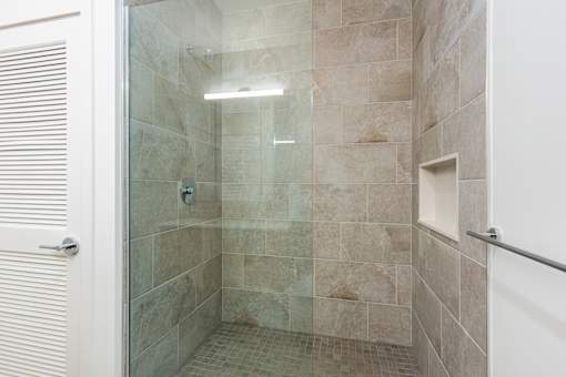 A bathroom with a walk-in shower and tiled walls.