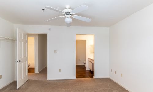 A room with a ceiling fan and two doors.
