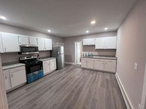 A kitchen with white cabinets and a blue accent on the countertop.
