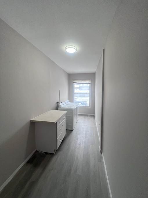 A long hallway with a desk and a window.