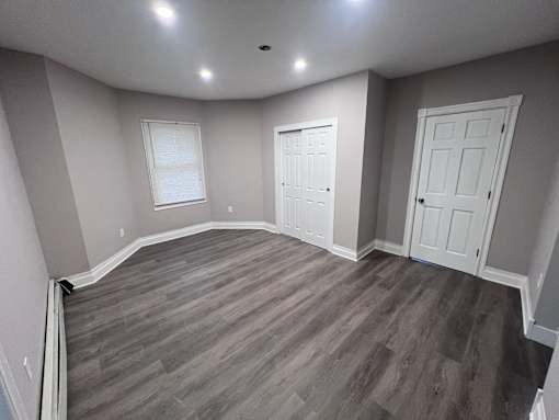 A room with a curved wall and wood flooring.