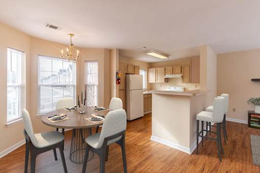 A kitchen with a table and chairs in front of a window.