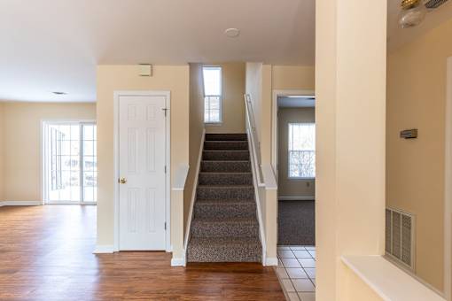 A staircase with a carpeted runner leads up to a second floor.