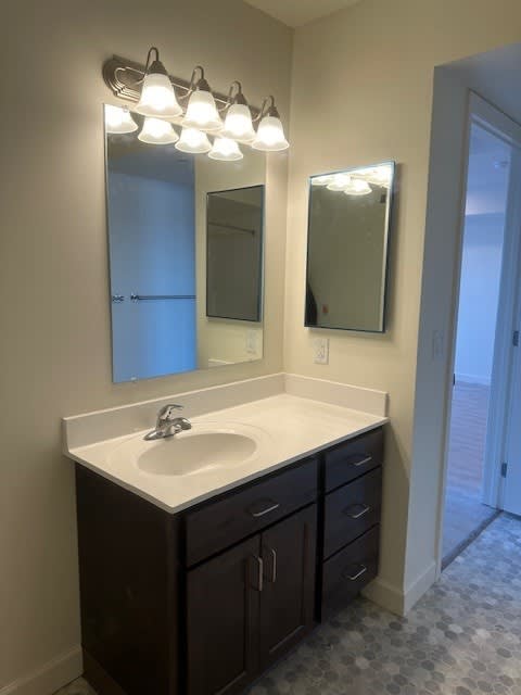 A bathroom with a sink and mirror.