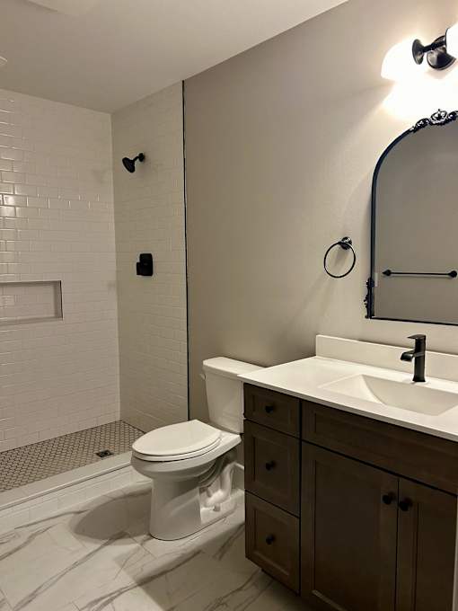 a bathroom with a toilet and a sink and a shower
