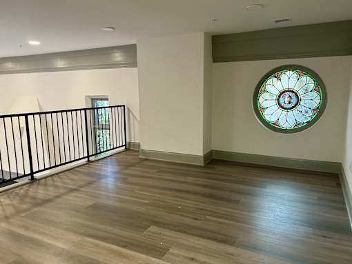 an empty living room with a stained glass window on the wall