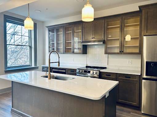 a kitchen with a large island and stainless steel appliances