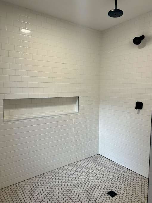a white tiled bathroom with a toilet and a sink