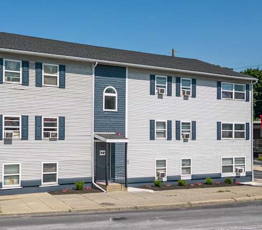 a white house with blue and white siding on a street