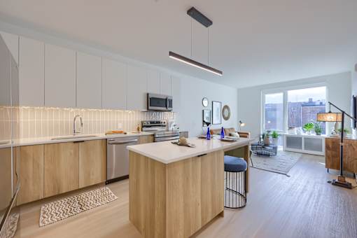 A modern kitchen with wooden cabinets and a bar stool.