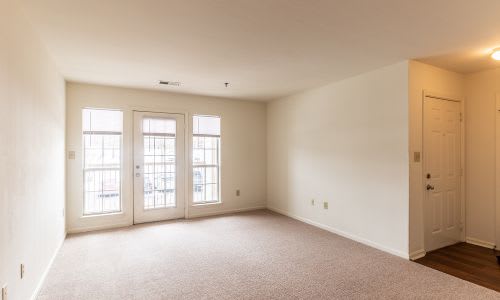 A room with a carpeted floor and a door on the right side.