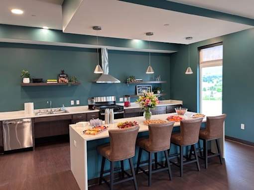 A kitchen with a table set for four with a view of the backyard.