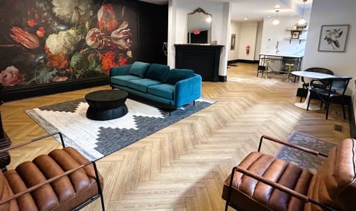 a living room with a blue couch and a large painting on the wall