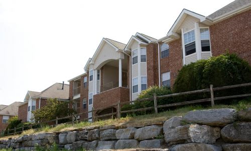 A row of houses with a stone wall in front.