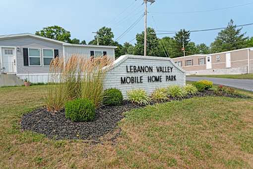 A sign that says Lebanon Valley Mobile Home Park in front of some homes.