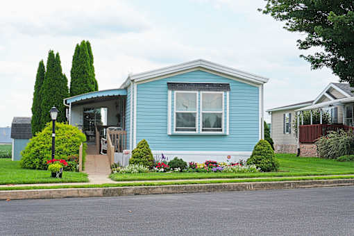 A blue house with a white roof and a small front yard.