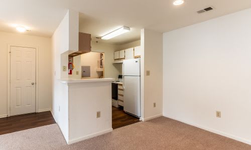 A kitchen area with a refrigerator, sink, and cabinets.