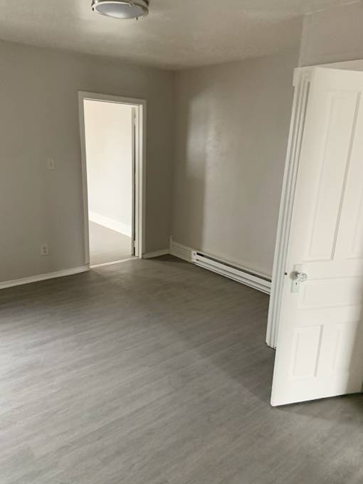 A room with a white door and a white wall.