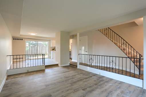 A spacious room with a staircase and a balcony.