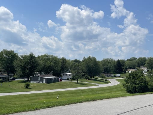an rv park on a grassy field with trees in the background