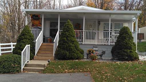 the front porch of a house with a porch swing