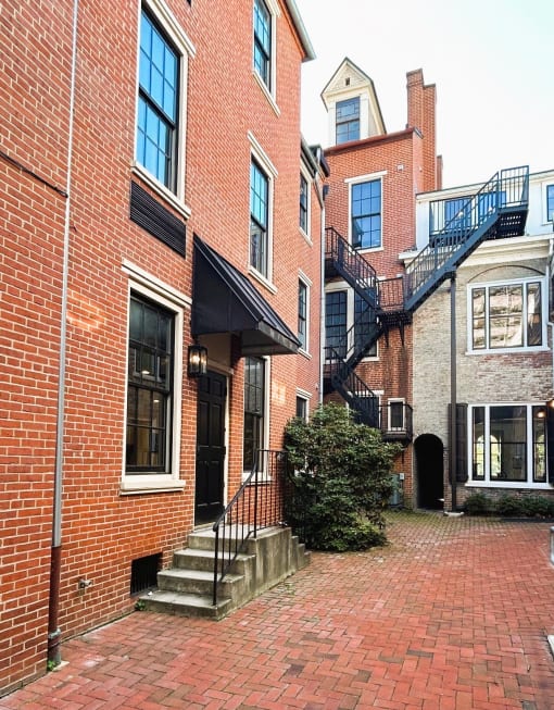 a brick sidewalk in front of a brick house