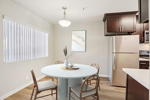 A kitchen with a table and chairs.