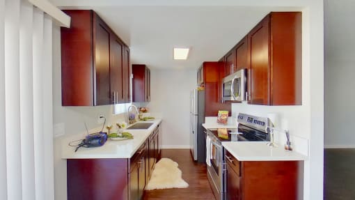 a kitchen with wooden cabinets and white counter tops and a stainless steel refrigerator