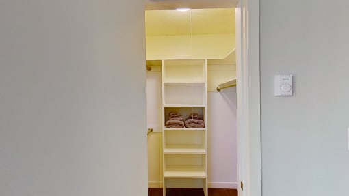 a walk in closet with shelves and a white door